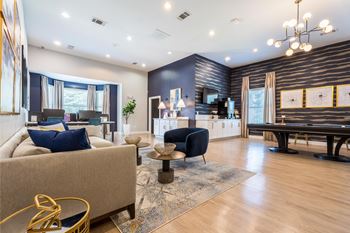 A living room with a sofa, a coffee table, and a pool table.